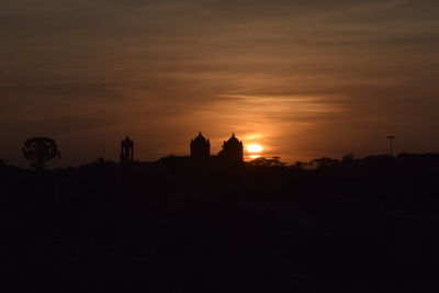 Silhouette of building against sky during sunset