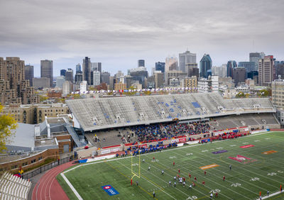 High angle view of soccer field in city against sky