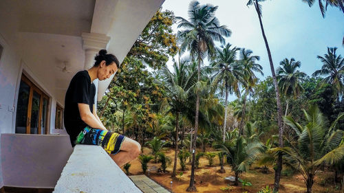 Full length of young man looking away against trees