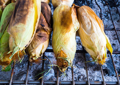 Corn is grilled on grill grates, thailand street food