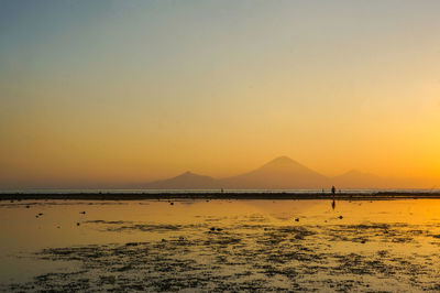 Scenic view of sea against orange sky