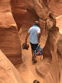 Rear view of man walking on rock formations