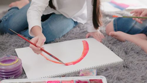 High angle view of woman drawing on book