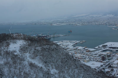 High angle view of frozen sea against city