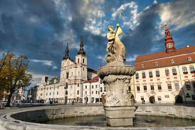 Statue and historic building against sky