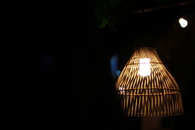 Low angle view of illuminated lamp in darkroom