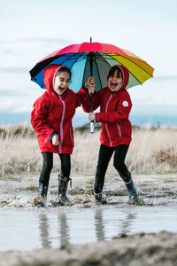 Full length of wet friends during rainy season