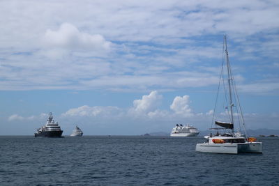 Sailboats sailing on sea against sky