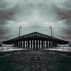 Pier on sea against cloudy sky