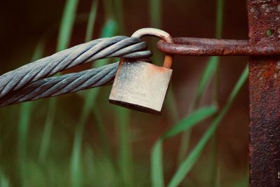 Close-up of padlock on rusty metal rope