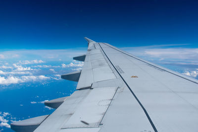 Airplane flying over clouds against blue sky