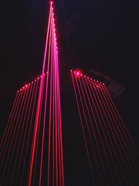 Low angle view of illuminated suspension bridge at night