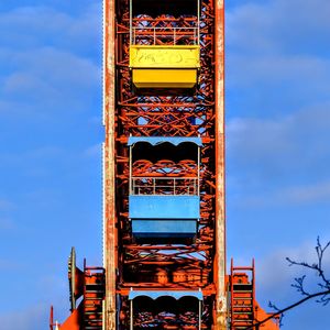 Low angle view of ferris wheel against blue sky