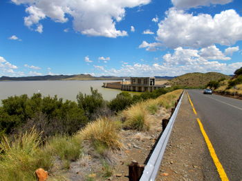 View of empty road along calm lake