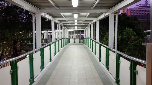 Empty footpath amidst illuminated building