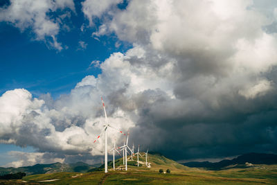 Windmill on field against sky