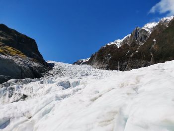 Scenic view of snowcapped mountains against clear blue sky