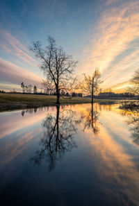 Scenic view of lake against sky at sunset