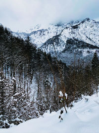 Snow covered land and mountains against sky