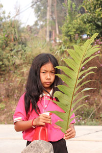Portrait of mature woman standing against plants