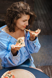 Young woman holding pizza slices