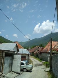 Houses by street against sky in city