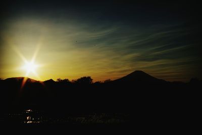 Scenic view of silhouette mountains against sky at sunset