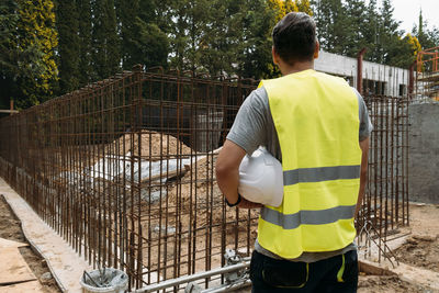 Man working with helmet from the back at construction site building private house and reinforced