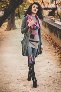 Full length of young woman walking on footpath