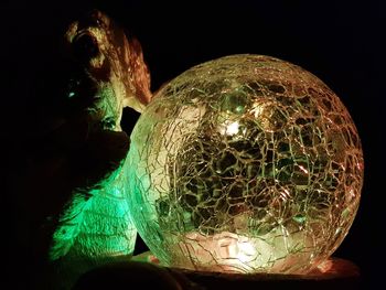 Close-up of illuminated lighting equipment against black background
