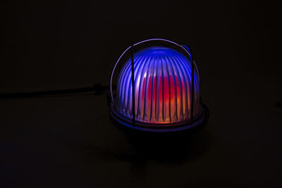 Close-up of illuminated light bulb against black background