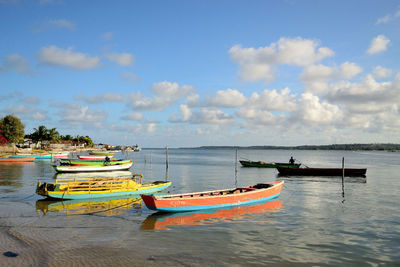 Boats moored on sea against sky