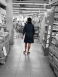 Rear view of woman walking in corridor of building