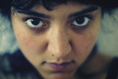 Close-up of portrait of young woman with freckles