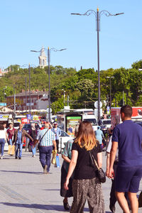 Rear view of people walking on street in city