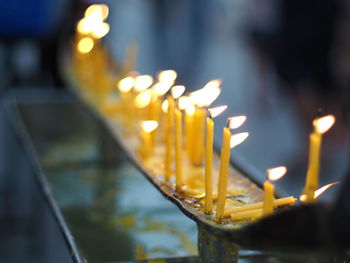 Close-up of lit candles in temple