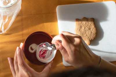 High angle view of woman holding coffee cup on table