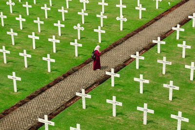 View of woman with her phone at cemetery