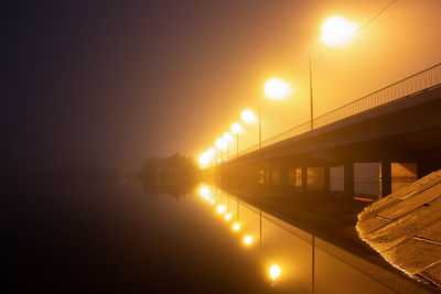 Illuminated bridge against sky during sunset