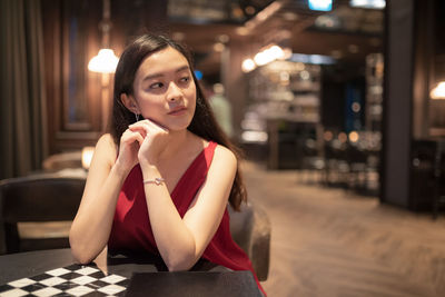 Portrait of young woman sitting on table