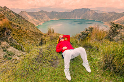 Rear view of man standing on landscape against mountains