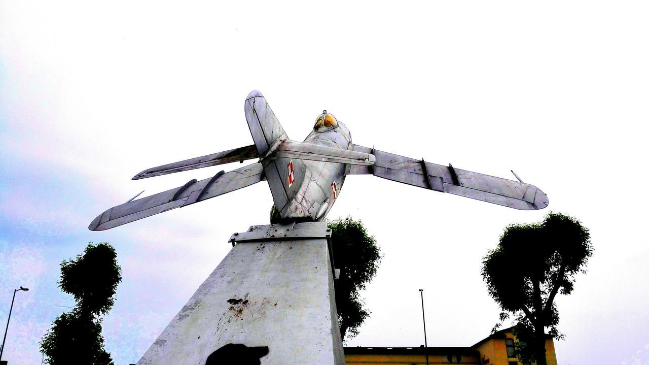 low angle view, built structure, clear sky, architecture, sky, copy space, tall - high, building exterior, history, tree, outdoors, day, travel destinations, no people, tower, travel, famous place, traditional windmill, crane - construction machinery, international landmark