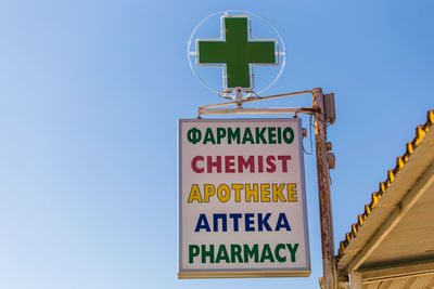 Low angle view of information sign against clear sky