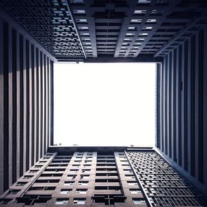 Directly below shot of buildings against clear sky