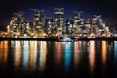 Illuminated buildings reflection in river at night