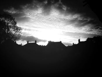 Silhouette buildings against sunset sky