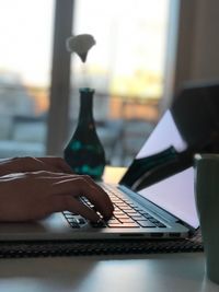 Cropped hands using laptop on table