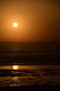 Scenic view of sea against orange sky