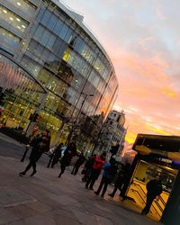 Tilt image of modern buildings against sky during sunset