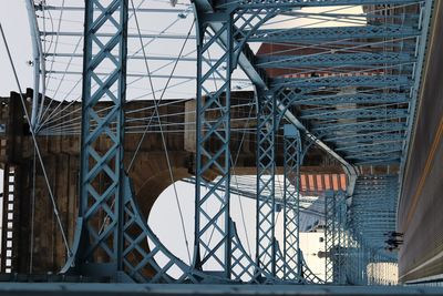 Low angle view of bridge by buildings in city